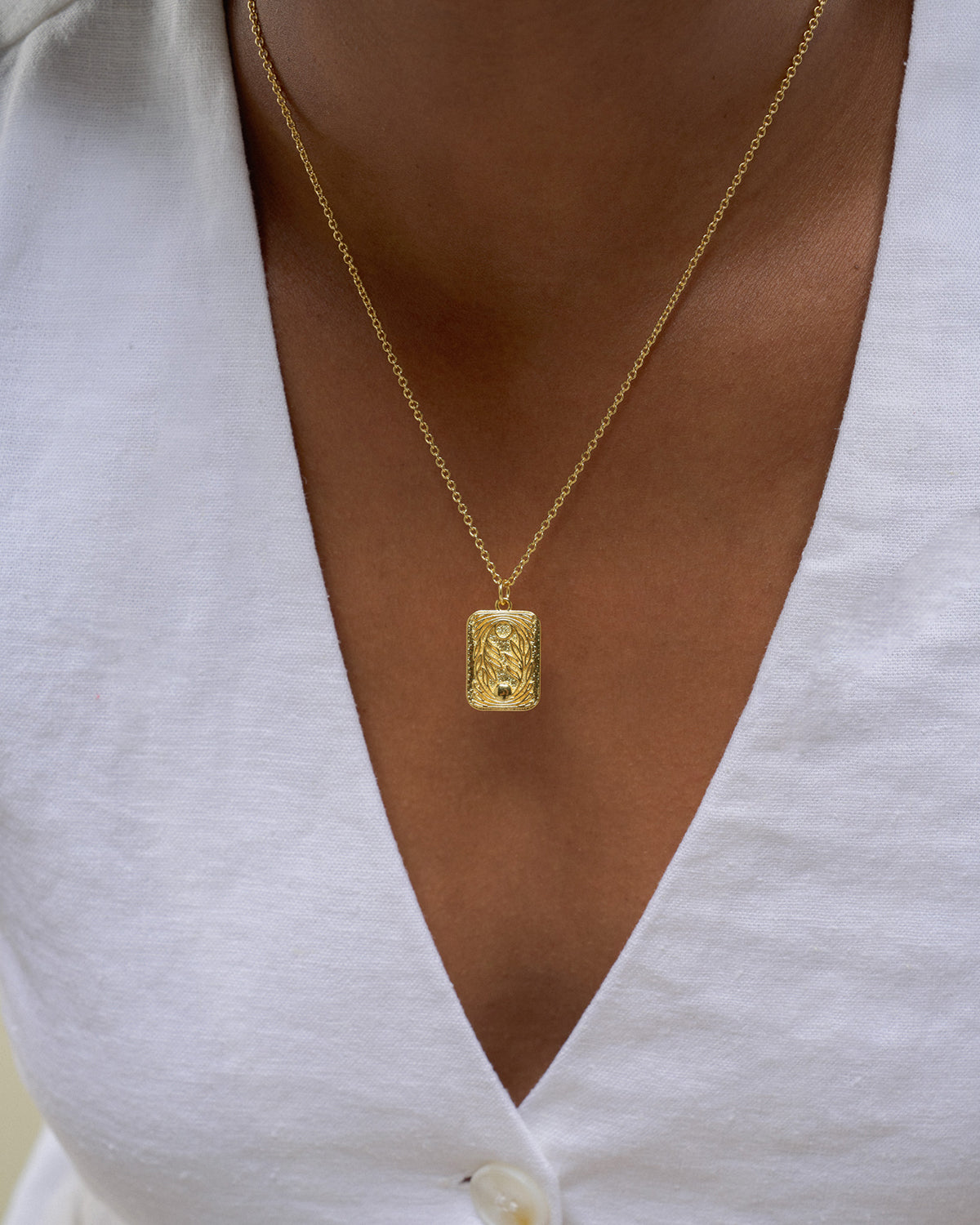 eine Goldkette mit Rechteckigen Sonne/Mond Anhänger.