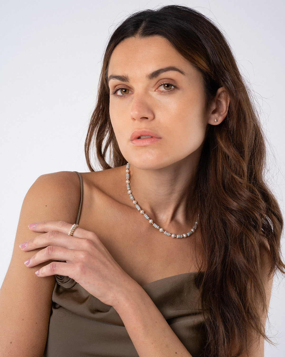 Frau trägt elegante Halskette für Damen mit Süßwasserperlen und hellblauen Edelsteinperlen – natürliche Perlenkette im minimalistischen Slow-Living-Stil.