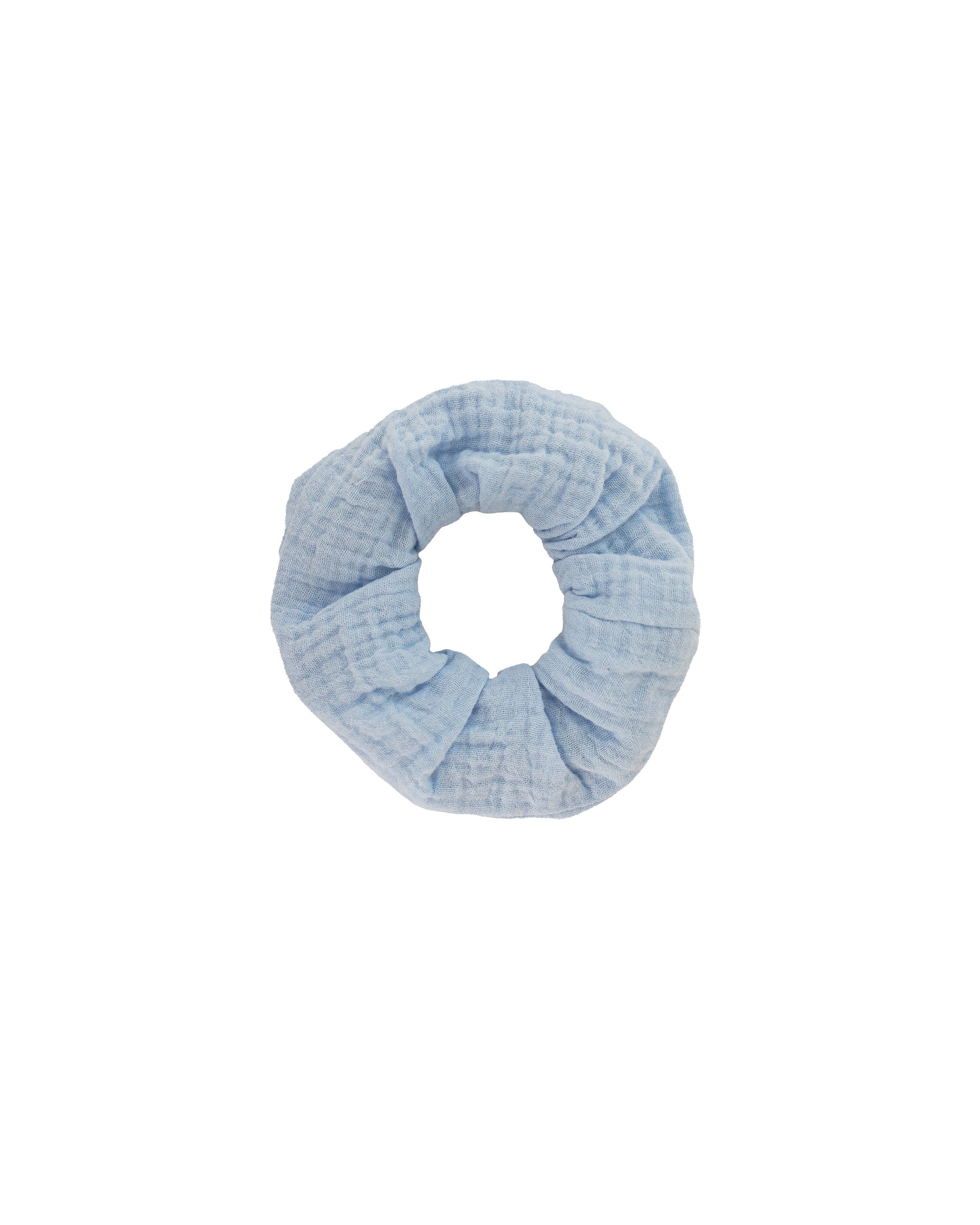 Hellblauer Scrunchie aus weicher Baumwolle, rund geformt und freigestellt vor weißem Hintergrund.